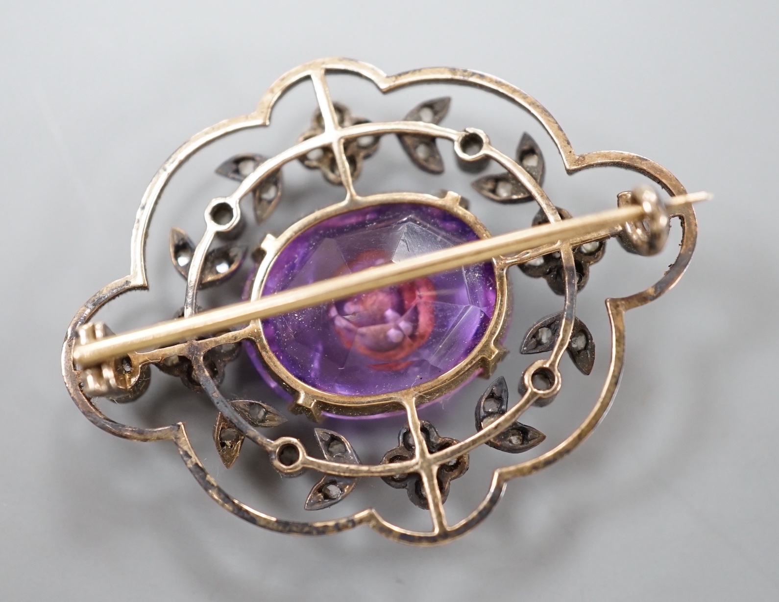 An Edwardian yellow metal, amethyst and rose cut diamond set shaped oval brooch, 34mm, gross weight 5.9 grams.